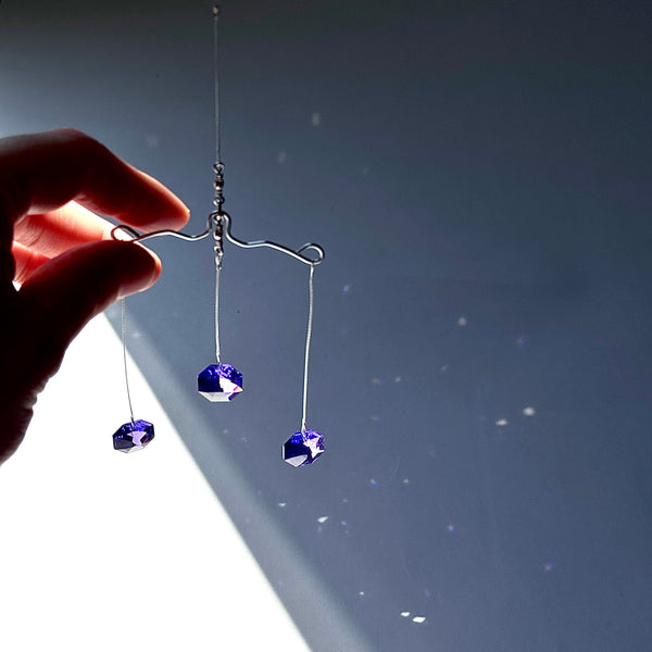 Pair of purple crystal earrings on a dark background